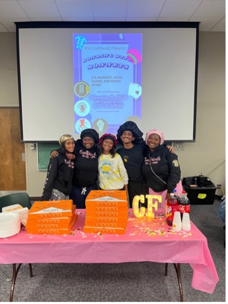 Group of students standing behind a table at an event