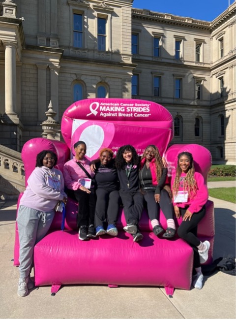 Group of students sitting in a large inflatable pink chair