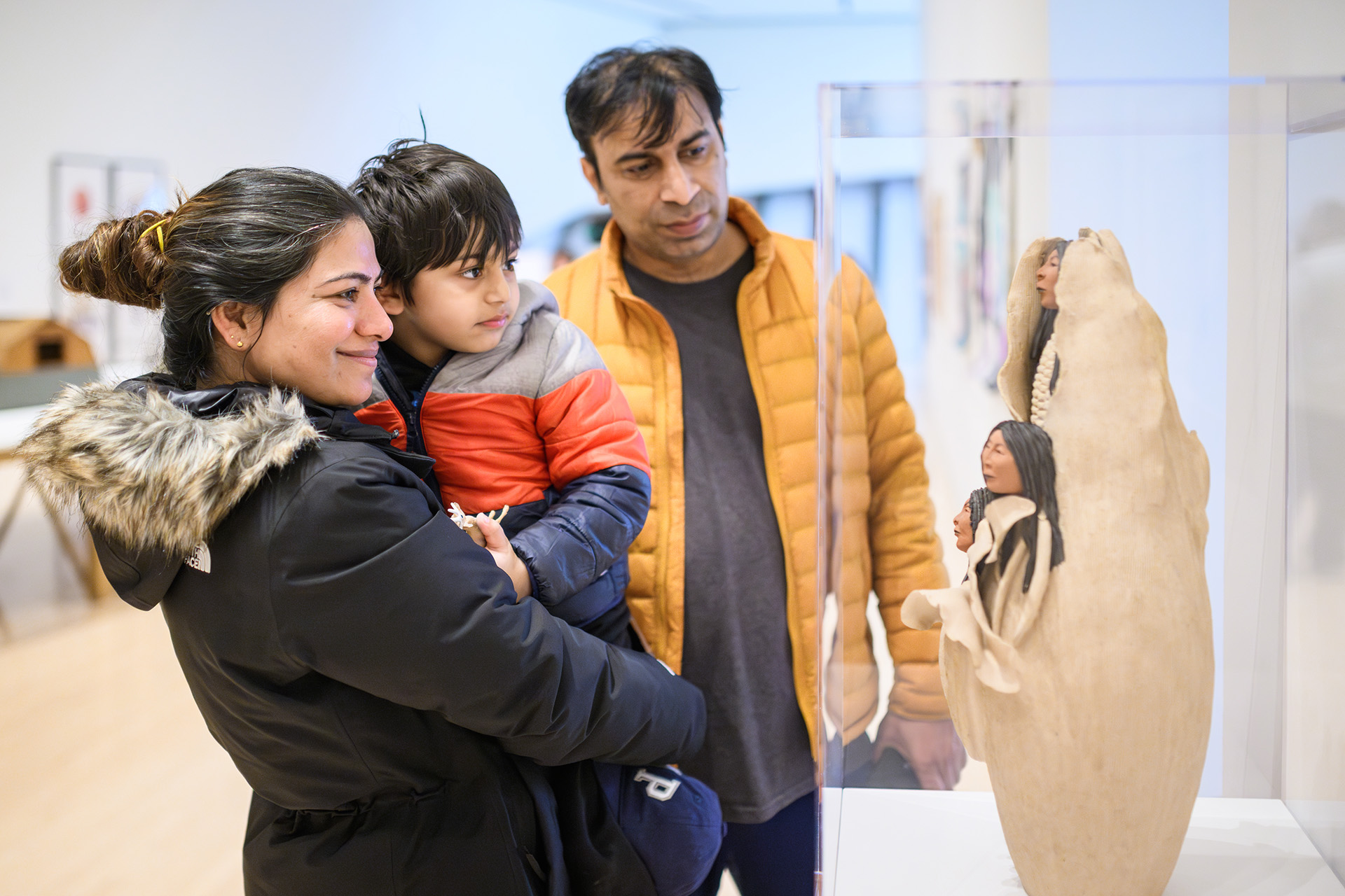 a family of museum visitors look at the three sisters sculpture