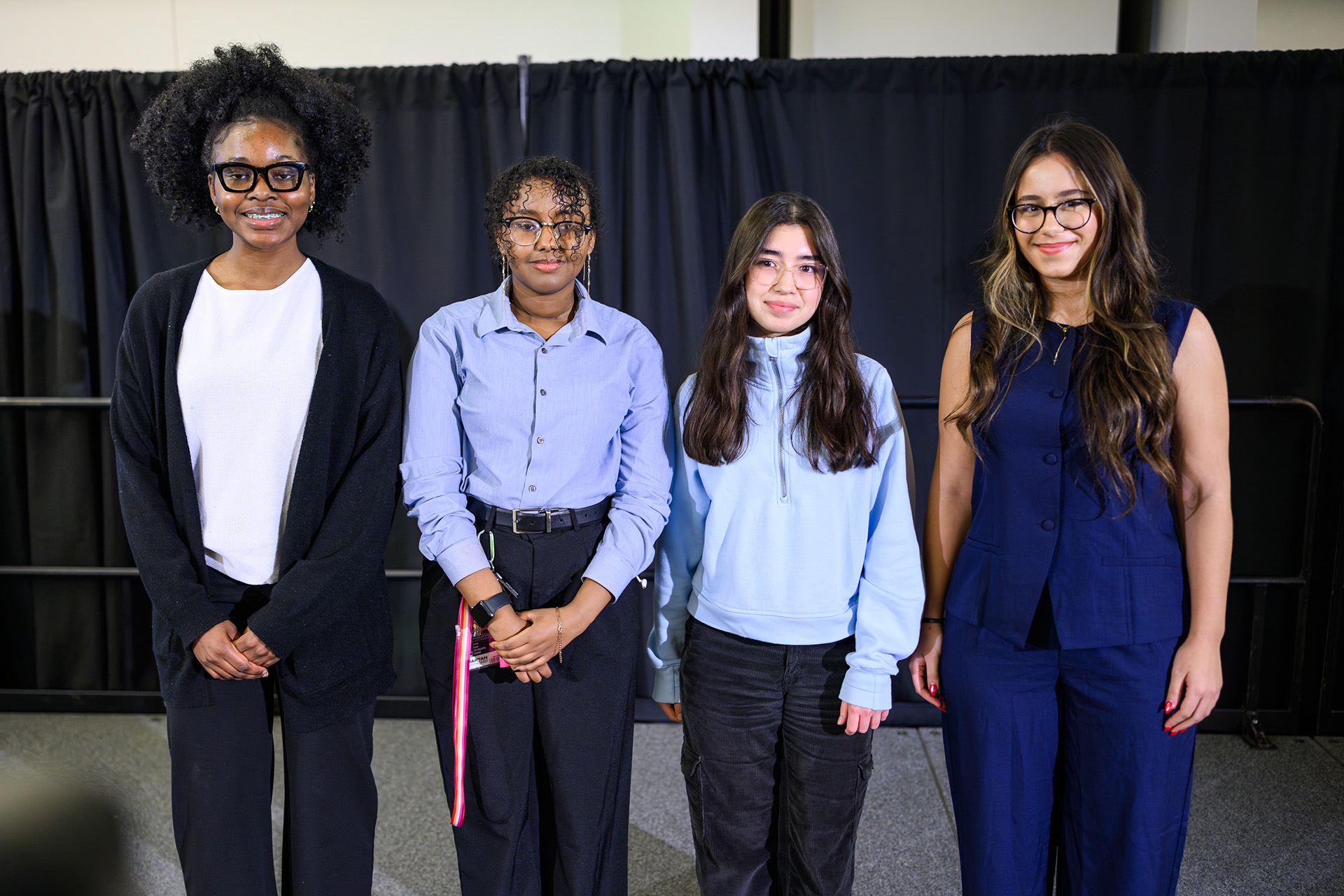 Four Dr. Martin Luther King Jr. Endowed Scholarship recipients pose for a photo on the stage