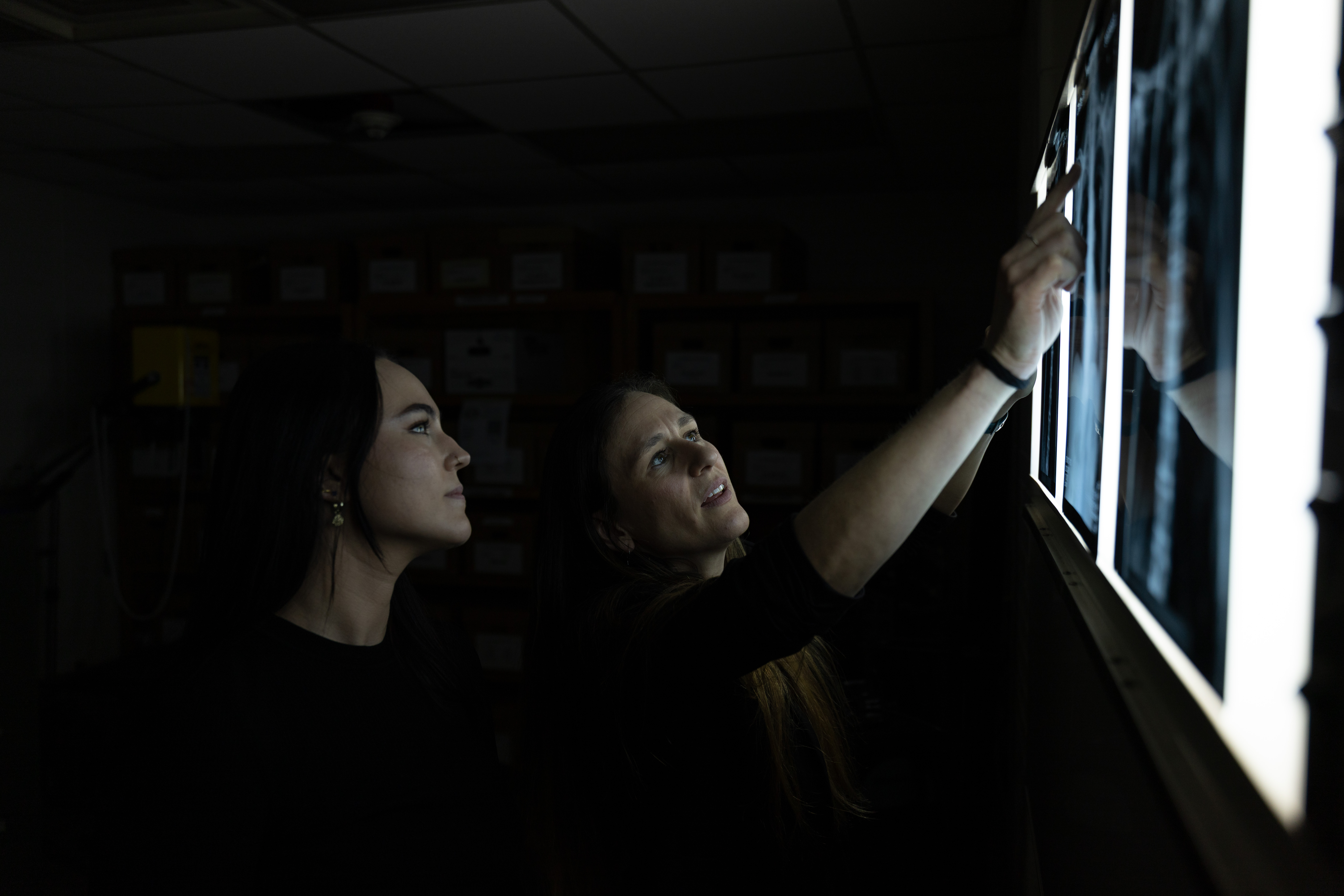 Doctoral student Alexis VanBaarle, left, and Dr. Carolyn Isaac, right, discuss chest radiographs.