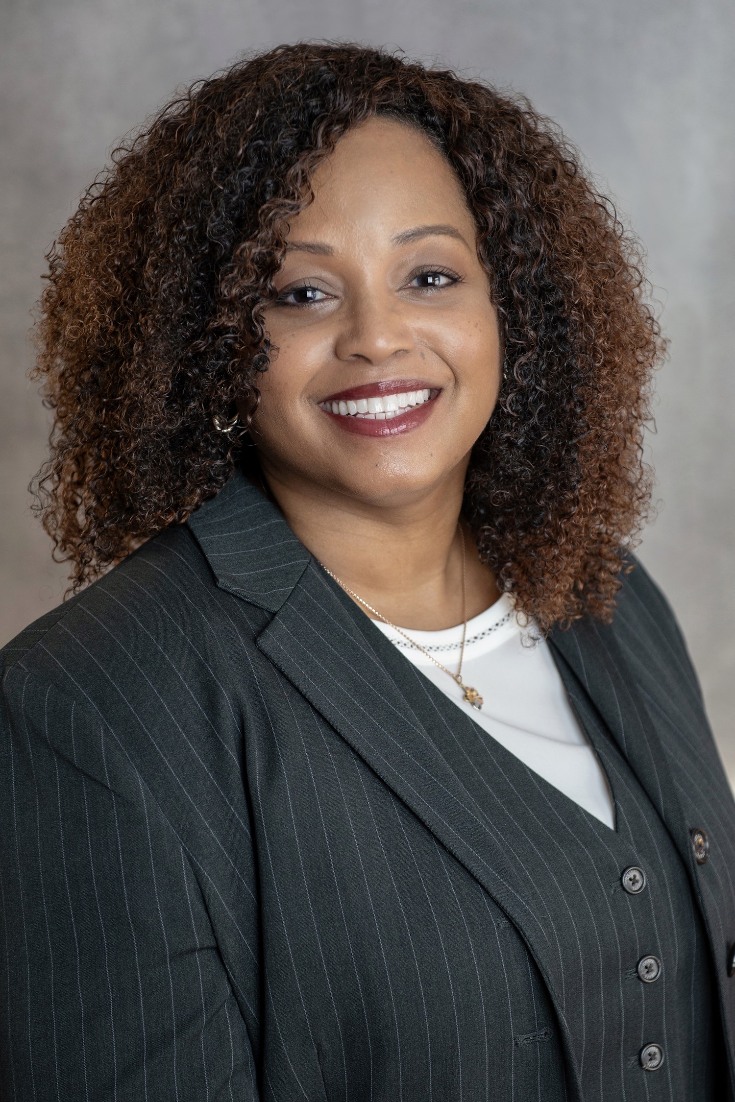 Portrait of a woman smiling in a sportcoat and white shirt