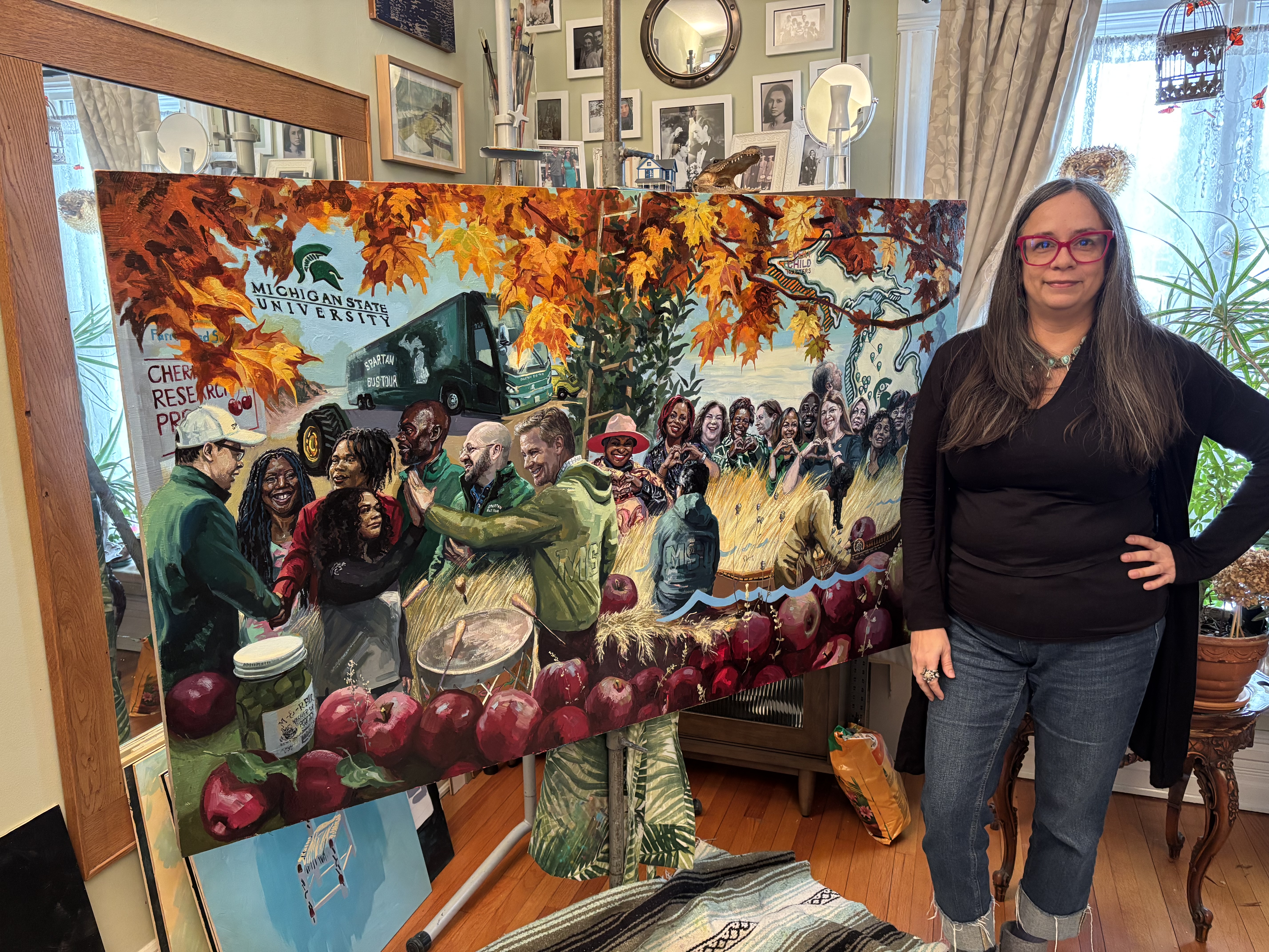 A person in front of a large piece of artwork.