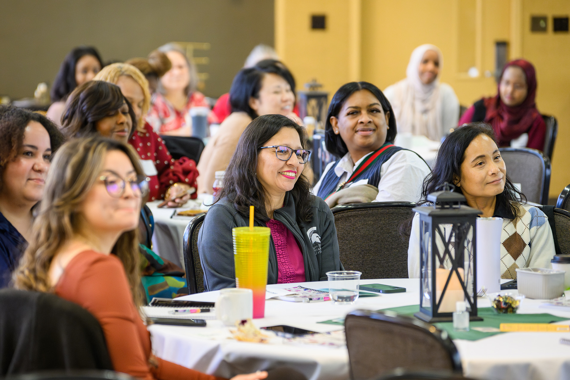 women sitting around conference room tables smiling