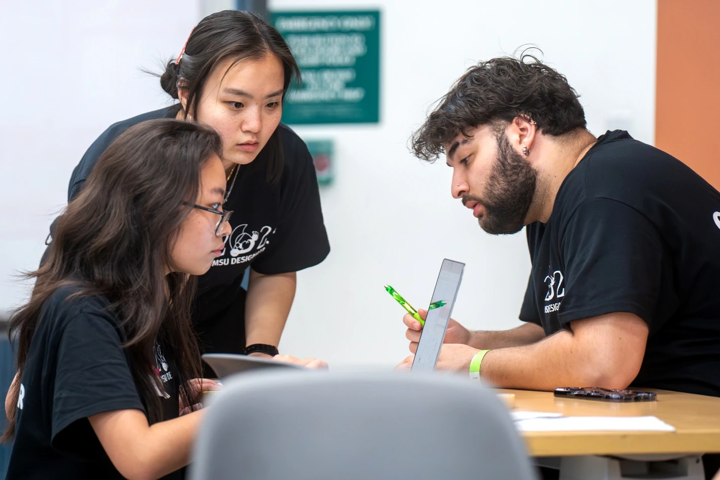 Lisa Chai, Rena Huang, and Julius Patto discussing judging for participants during the last few hours of the MSU Designathon. (Photo by Darrian Chen)